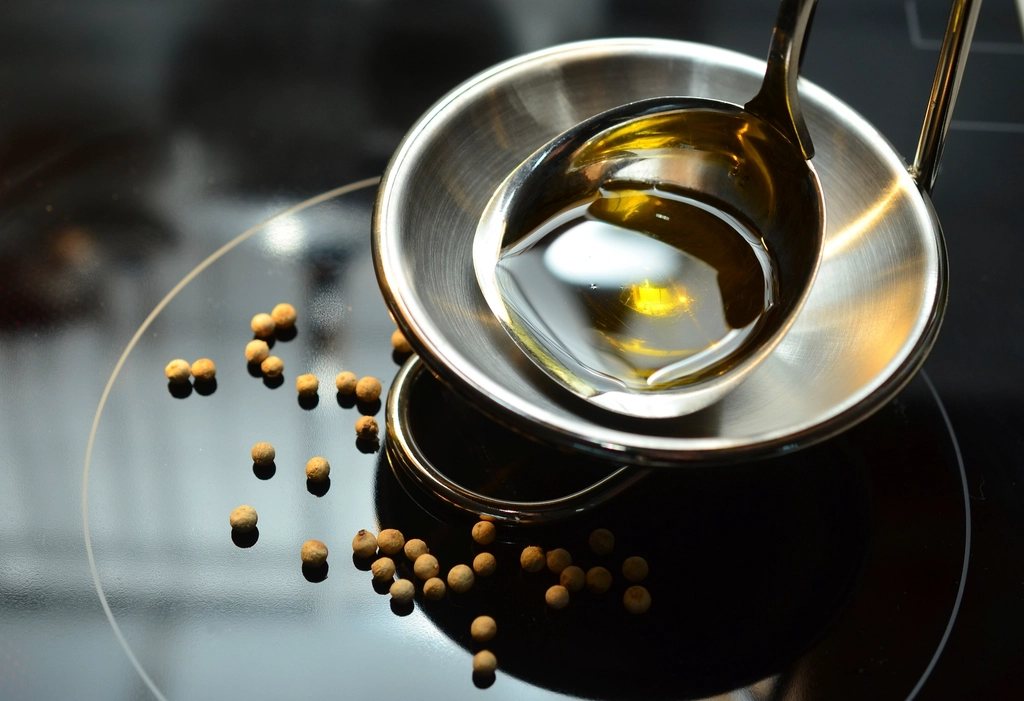 Huile d’olive versée dans des cuillères de cuisine